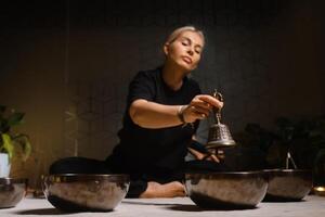 Practicing mindfulness and meditation with singing bowls in a tranquil indoor setting during a holistic wellness session.. photo
