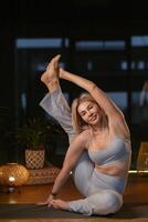 Yoga practitioner demonstrates impressive flexibility in serene studio setting during evening relaxation session with soft lighting.. photo