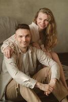 Couple relaxing together indoors, sharing a moment of joy and connection, surrounded by soft lighting and neutral tones, creating a warm atmosphere photo
