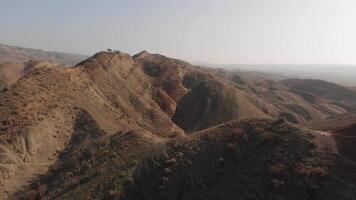 Drone footage capturing excursion tourist group on viewpoint enjoy breathtaking panoramic view of vibrant, multicolored mountain ranges, showcasing nature stunning palette and rugged terrain. video
