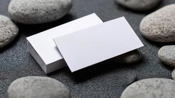 Two white business cards are placed on top of each other on a black surface photo