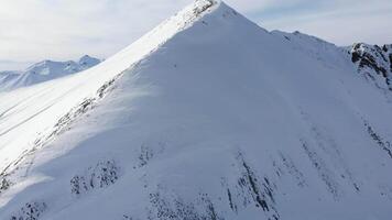 Drone view over Kobi ridge with minimal snow on Caucasus peak, symbolizing warming climate, early thaw, and reduced ski season in Georgian mountains video