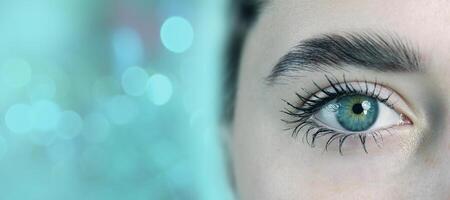 Close-up of a captivating eye with striking colors situated against a blurred turquoise backdrop photo