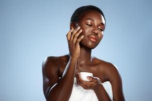 Woman applying moisturizer while enjoying a self-care routine in a serene, minimalistic setting photo