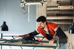 Construction worker performing tasks at a building site while adjusting equipment on scaffolding photo