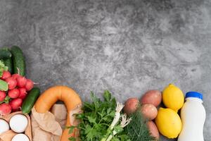 Flatlay of classic okroshka components, including chopped veggies and herbs, on a gray tabletop. photo