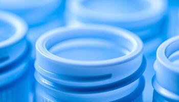 Close-up View of Circular Container Openings in Blue Illumination at a Production Facility photo