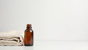 A bottle of essential oil sits on top of a towel photo