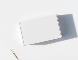 An empty white box with a pair of scissors on top photo