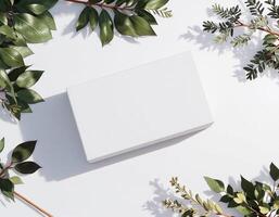 White box mockup with green leaves on white background photo