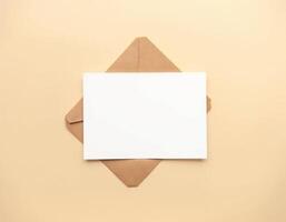 Blank white envelope with brown envelope on beige background photo