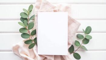 Blank white card with eucalyptus leaves on white wooden background photo