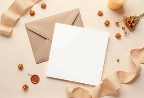 Blank white envelope with flowers and ribbon on a beige background photo
