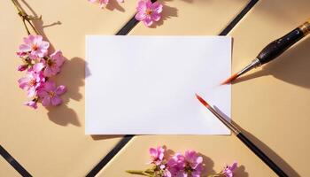 A blank sheet of paper and paint brushes on a table photo