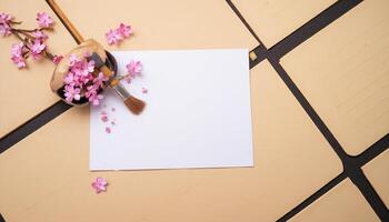 A blank sheet of paper, a brush and a flower on a table photo