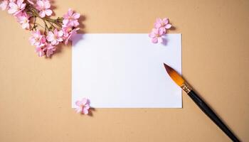 A blank sheet of paper and a paintbrush on a beige background photo