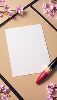 A blank sheet of paper and a red pen on a wooden table photo