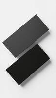 Two black rectangular pieces of paper on a white surface photo