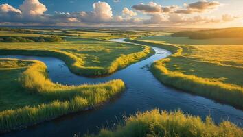 Scenic River Flowing Through Green Meadow at Sunset with Clouds photo