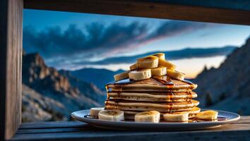 Stack of Pancakes with Banana and Syrup Against Mountain Backdrop photo