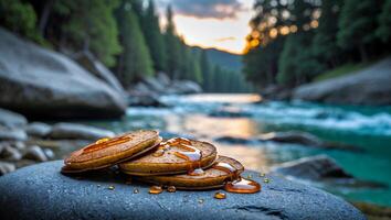 Pancakes with Syrup Stacked on Rock at Riverbank Scene photo