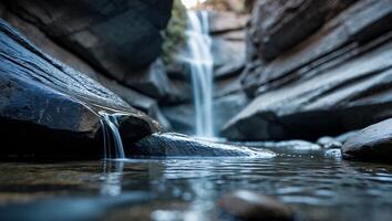 Waterfall Flowing Through Rocky Canyon with Clear Water and Reflections photo