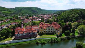 Aerial backwards view of chateau Zbraslav and creek in Czechia in May 2025 video