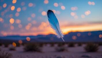 Floating Feather Over Desert Landscape at Sunset with Bokeh Lights photo