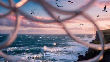 Ocean Waves Crashing on Cliffside with Birds Flying at Sunset photo