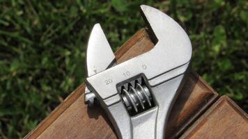Tools resting on wooden surface after outdoor maintenance work in a garden during bright daylight photo