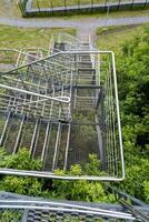 This aerial view showcases steps framed by vibrant green trees, enhancing the tranquility and natural beauty of this outdoor setting, inviting the observer to enjoy nature photo
