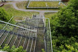 This image captures an aerial view showcasing a fire escape that is beautifully surrounded by a lush landscape of trees and green grass, creating a striking visual contrast photo
