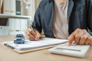 Man signing car insurance on paperwork assurance. Buying or selling new vehicle. Ownership for new photo