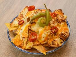 Nachos with cheese, jalapeno and chili pepper photo