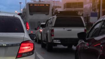 Abstact traffic jam with several vehicles lined up on a road. Close up car with its tail lights illuminated. Traffic congestion during rush hour with environment of rainy time at eveing. photo