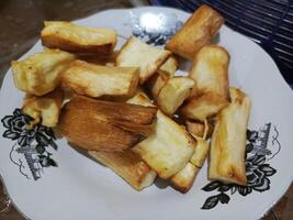 Golden fried sweet cassava slices on a patterned plate a simple and delicious snack photo