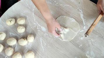 Crafting Gozleme Dough With Skillful Hands and a Rolling Pin in a Warm Kitchen Setting video