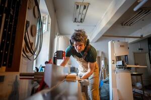 Skilled carpenter apply full attention to precision work on jointer machine processing wooden beam photo
