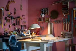 Woodworking studio featuring handmade lamp on worktable. Custom built light item made from plywood photo