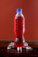 Red soft drink bottle with a red background photo