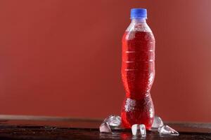 Red soft drink bottle with red background photo