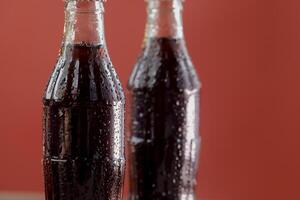 Soft drink bottle with red background photo