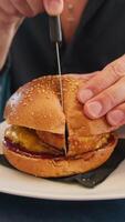 Man Dividing A Burger With Fish In Two Parts With The Knife In Italy video