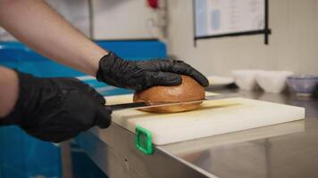 Chef Slicing In Half A Bun To Start The Preparation Of The Burger Indoor video