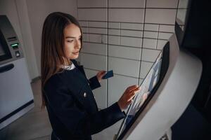 Woman is using banking terminal indoors photo