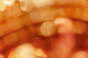 Defocused abstract bokeh background yellow golden color, flare from lights, monochrome photo, blurred round bokeh as holiday fon, celebration wallpaper. Glittering aesthetic textured photo pattern.