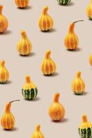 Top view pattern of Decorative pumpkins on beige background, Minimal style modern still life, autumn or fall season holiday or harvest concept. Autumnal mini gourd or squash, stylish photo
