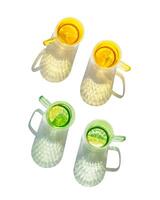 Set Top view colored Glasses of Drinking natural water with slises of lemon, orange, shadow and sunlight reflection isolated white background, Summer drink in yellow green glass cups with handles photo