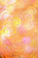 Blurred abstract bokeh background peach trend color, flare from lights, color gradient, blurred figured bokeh as holiday texture. Glittering monochrome aesthetic textured lighting pattern photo