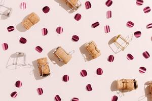 Champagne corks and sparkling confetti, top view composition, holidays, celebration concept. Wooden cork and muselet on pastel background at sunlight shadows. Flat lay festive minimal layout photo